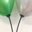 Two Balloons Tied To Balloon Sticks