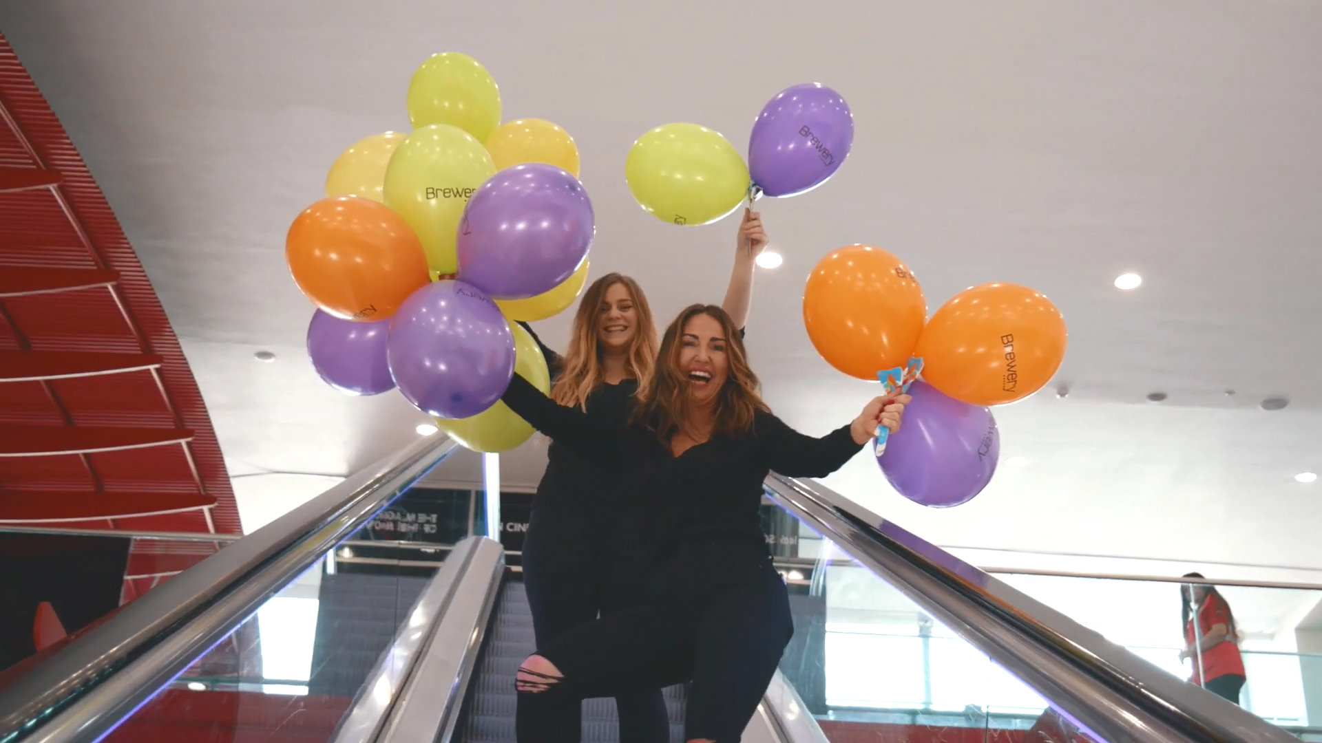 Women Holding Bunches of Branded Balloons on BalloonGrip